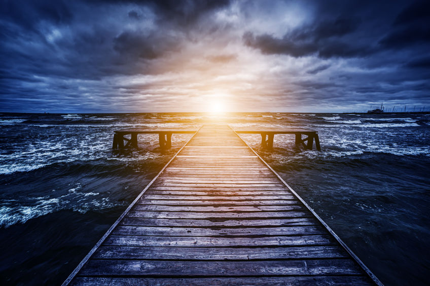 Maneuvering the Storms of Life - Bob Sawvelle - Old wooden jetty during storm on the ocean. Abstract light at the end