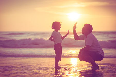 Childlike Faith - Bob Sawvelle - Father and son playing on the beach at the sunset time