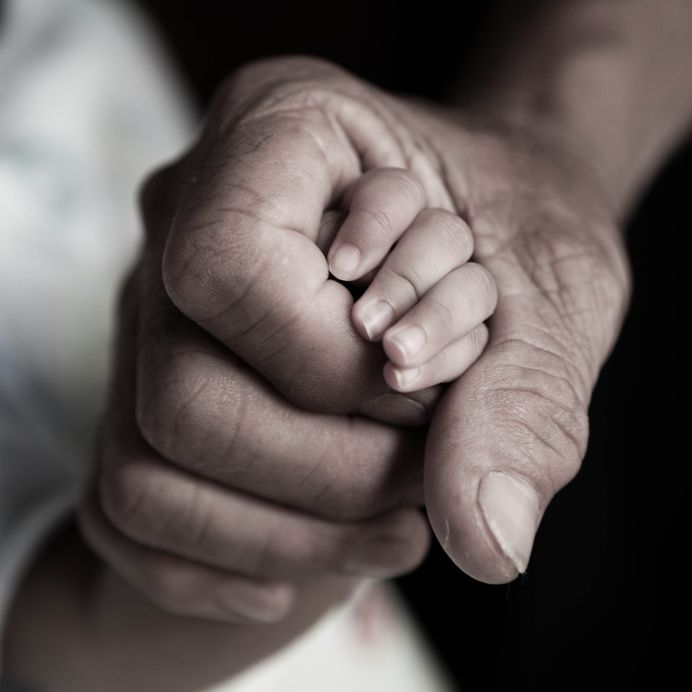 Under His Shadow - Bob Sawvelle - parent hand holding baby hand